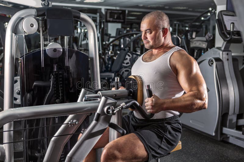 Man doing workout with pull-down machine stock image Man doing workout with pull-down machine stock image