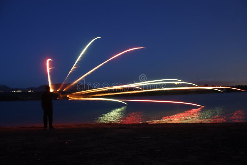 Man drawing a rainbow in the sky stock photo