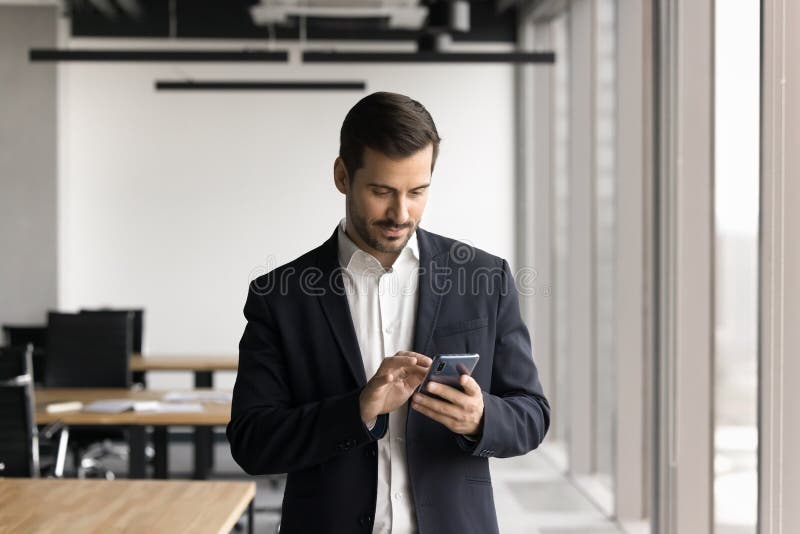 Man dressed in suit using smartphone in coworking space royalty free stock photos