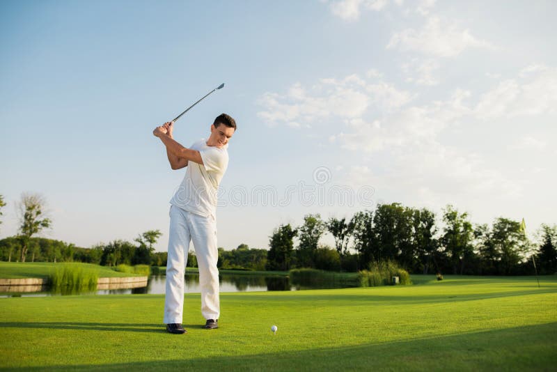 An athlete in a white suit took a golf club to strike stock images An athlete in a white suit took a golf club to strike stock images