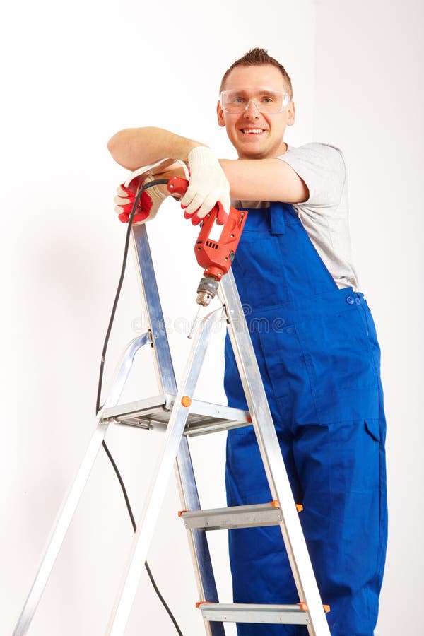 Man with drill standing on ladder stock images