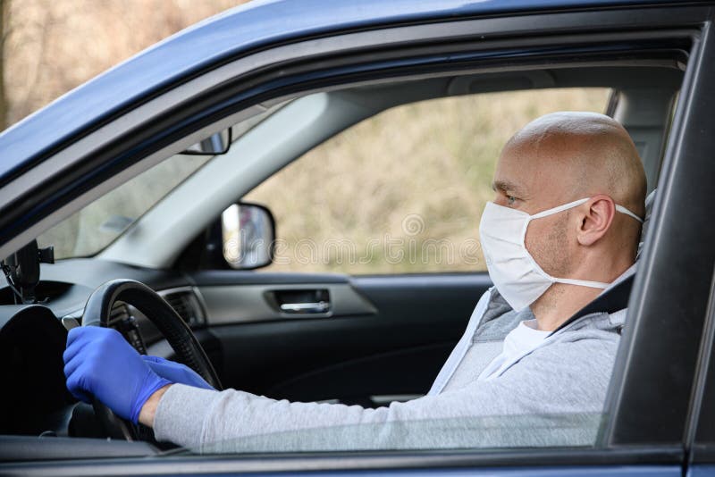 Man driving a car in medical protective mask stock images Man driving a car in medical protective mask stock images