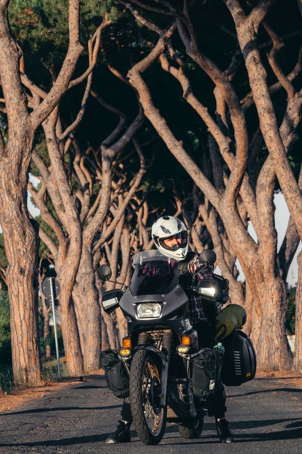 Man Driving a Touristic Motorcycle. Standing on the Road. in the Background  are Beautiful Pine Trees Stock Image - Image of cross, motion: 182974315