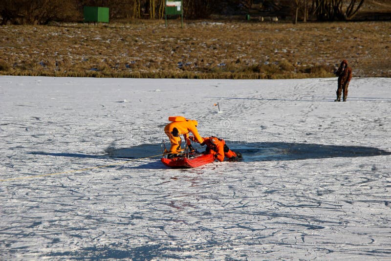 A man is drowning in icy water. A man in a special suit is drowning in a frozen lake