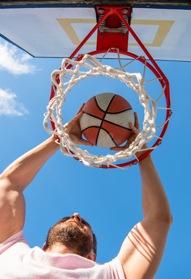 Man Dunking Basketball Ball through Net Ring with Hands, Success Stock