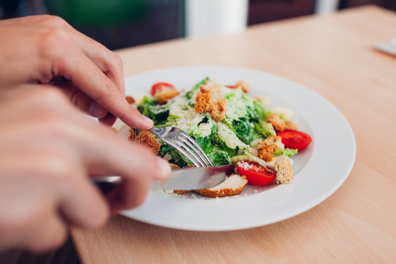 Man eating Caesar salad in restaurant. Having tasty healthy food. royalty free stock photo Man eating Caesar salad in restaurant. Having tasty healthy food. royalty free stock photo