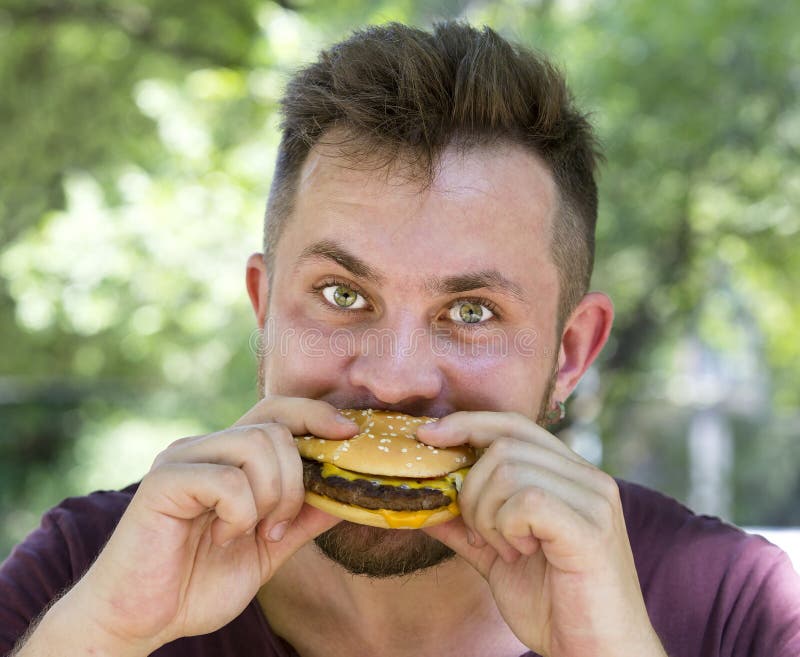 Man eating a hamburger. Expression, belly.