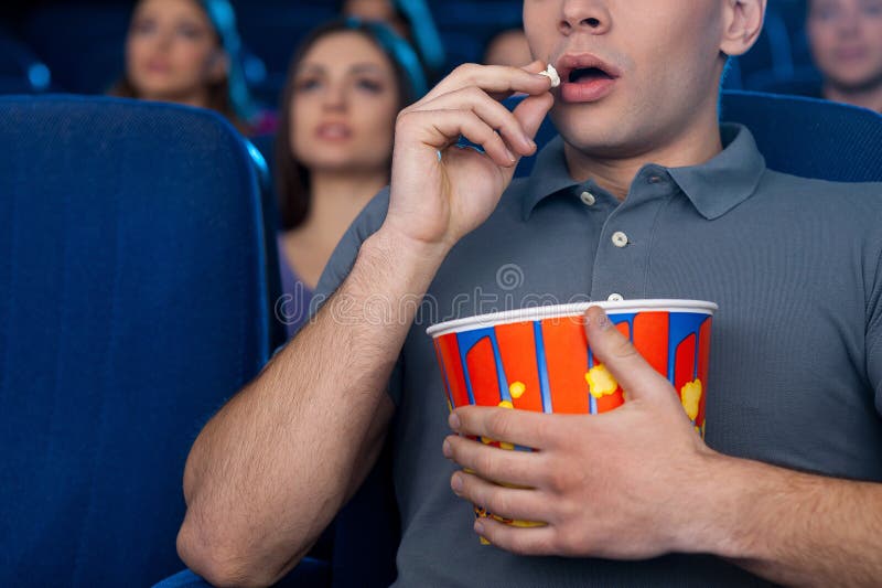 Man Eating Popcorn at the Cinema. Stock Photo Image of expression