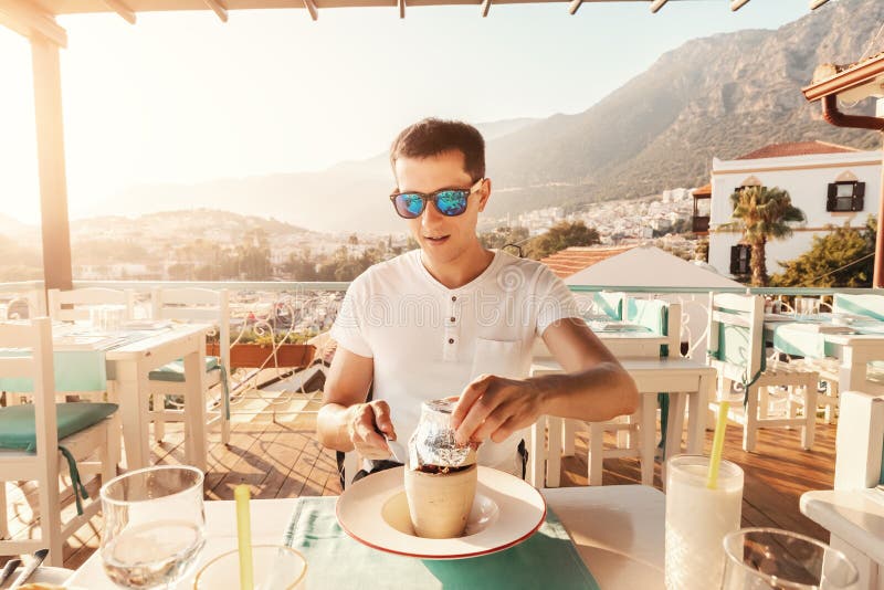 Man eating Testi kebab in restaurant on a terrace. It is an authentic Turkish delicious meat dish baked in a clay pot royalty free stock photos