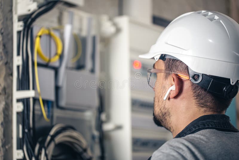Man, an Electrical Technician Working in a Switchboard with Fuses