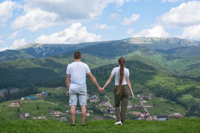 Man en de vrouw die zich op de heuvel de bevinden en bewonderen de mening van mo stock afbeelding Man en de vrouw die zich op de heuvel de bevinden en bewonderen de mening van mo stock afbeelding