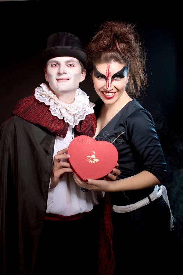 Man en vrouw die als vampier en heks dragen. Halloween stock foto Man en vrouw die als vampier en heks dragen. Halloween stock foto