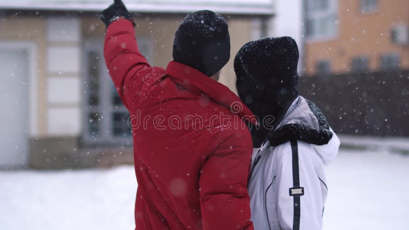 Man en vrouw die zich in de winterbinnenplaats bevinden De mensenpunten omhoog, meisje koestert hem dichte omhooggaand Het gelukk