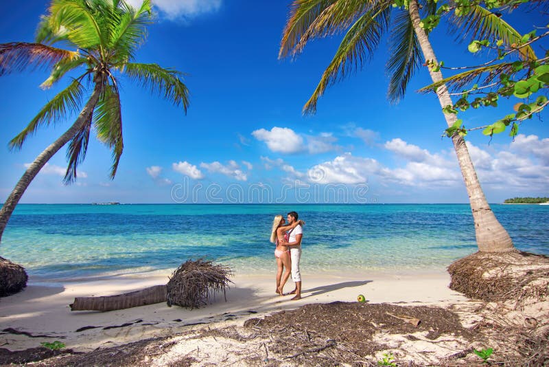 Man and women - romantic meeting on the ocean shore with palms. Man and women - romantic meeting on the ocean shore with palms