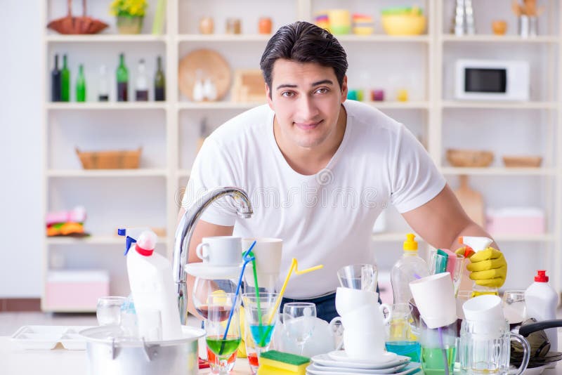 The man enjoying dish washing chores at home. Housekeeping, house.