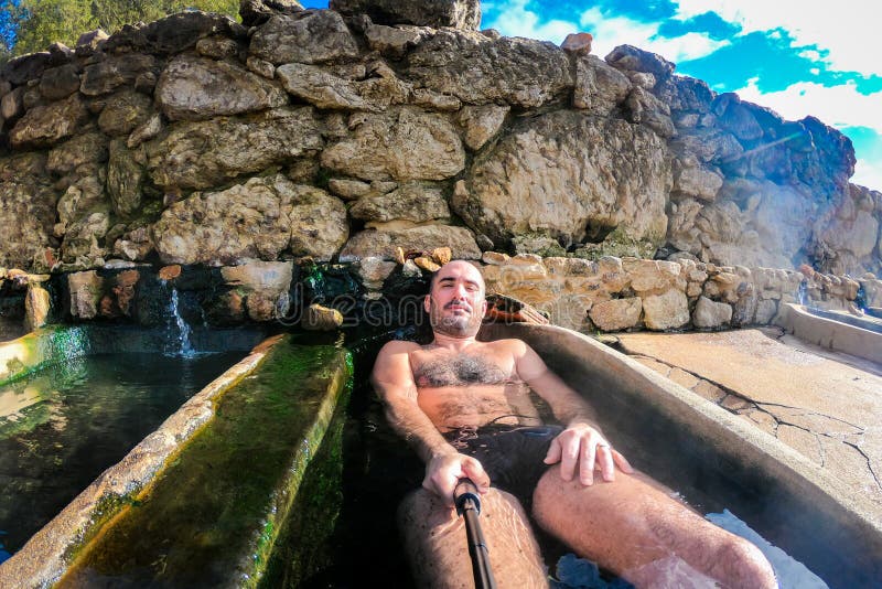Man enjoying and relaxing in natural thermal water roman spa