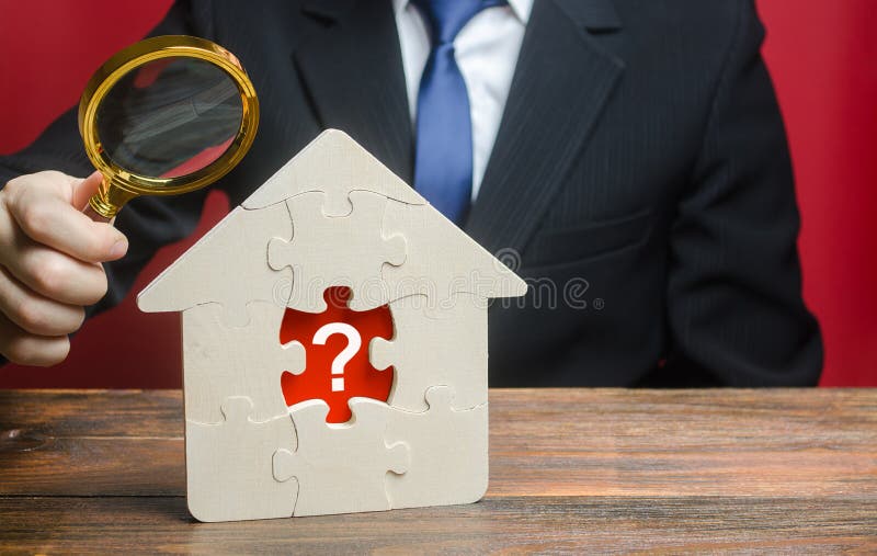 A man examines a house with a missing puzzle inside. Property valuation. Finding problems and structural hidden defects. Checking