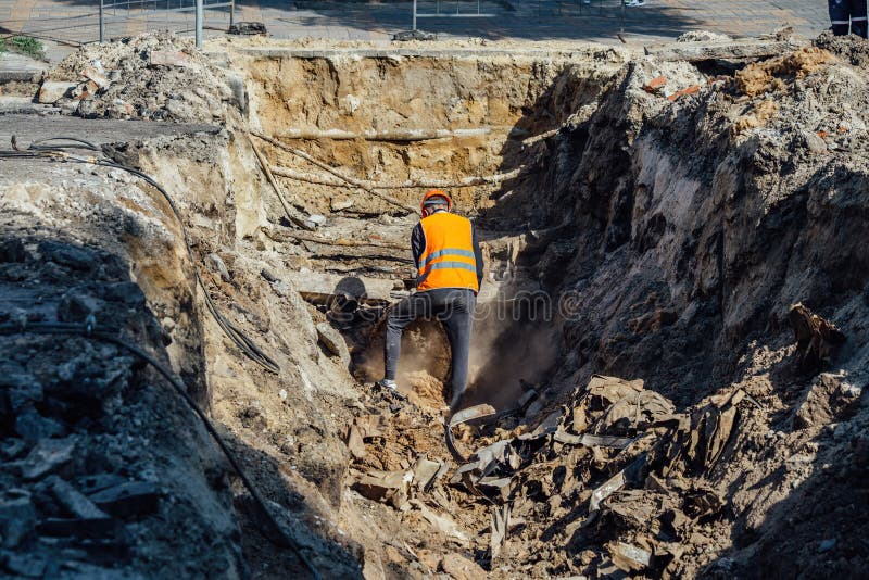 Man examining an excavation of old broken water supply or sewer pipeline royalty free stock photos