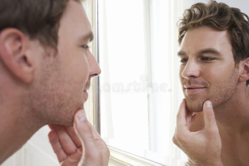 Man Examining His Stubble In Mirror