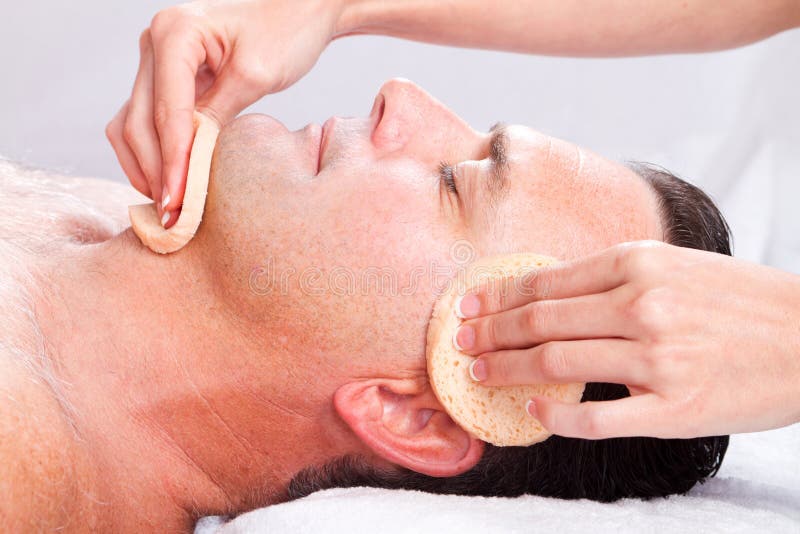 Middle age man receiving facial massage in beauty spa. Middle age man receiving facial massage in beauty spa