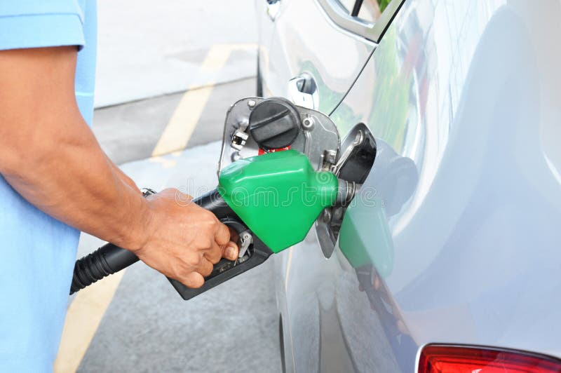 A man filling up the gas tank of a car