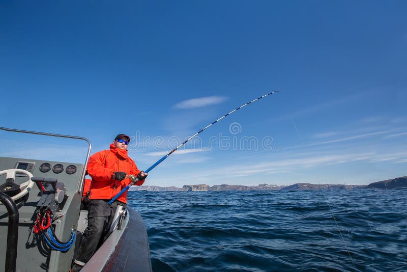 Man with a Fishing Rod on a Boat Looking into the Distance. Red