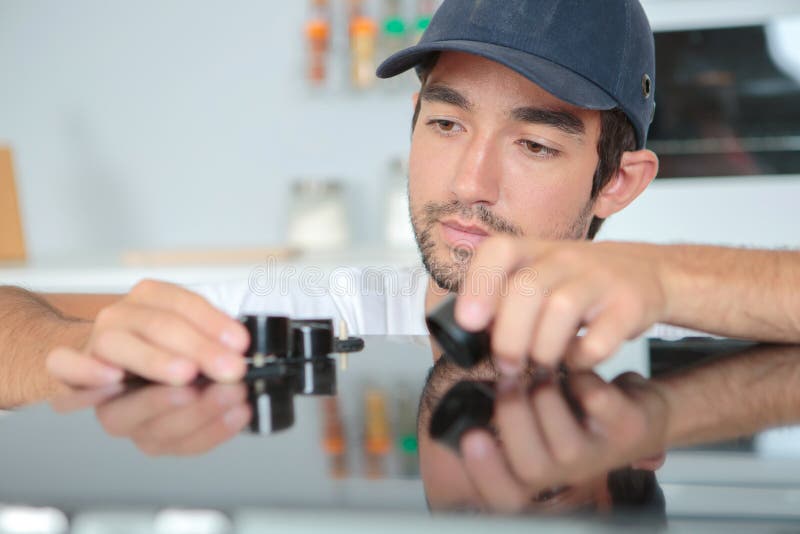 Man Fitting Knobs To Kitchen Hob Stock Photo Image of technician