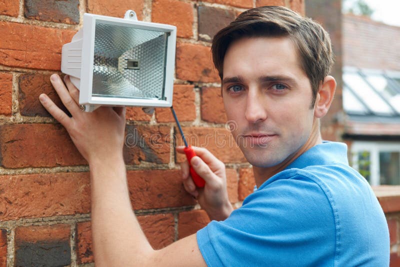 Man Fitting Security Light To House Wall Stock Image Image of