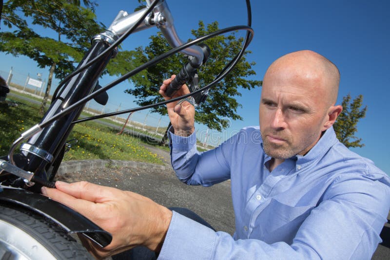 Man Fixing Bike Wheel at Park Stock Photo Image of bicycle, ride