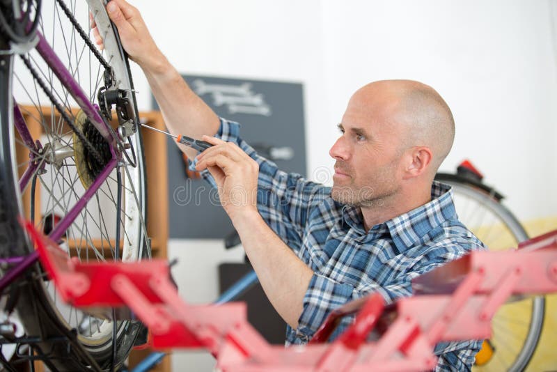 Man Fixing Bike Wheel in Store Stock Image Image of cyclingtrips