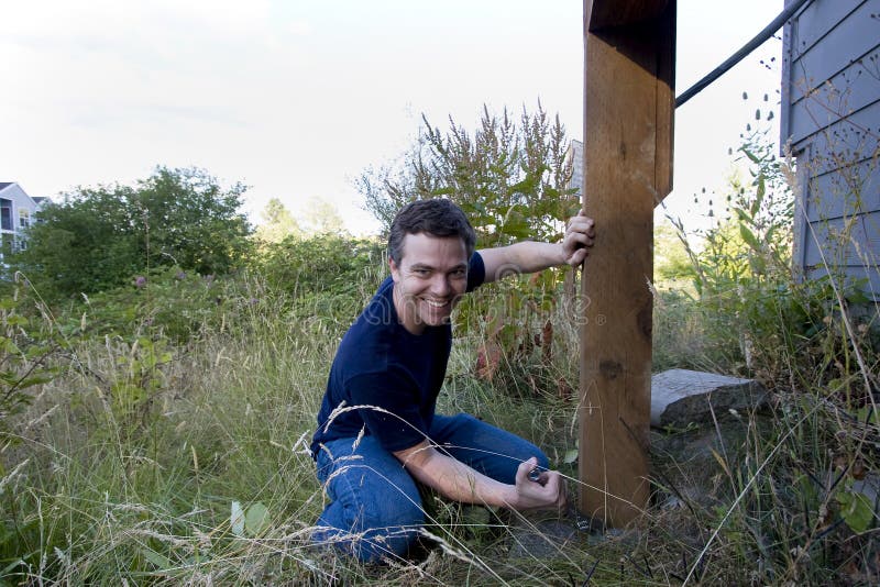 Man Fixing House - Horizontal