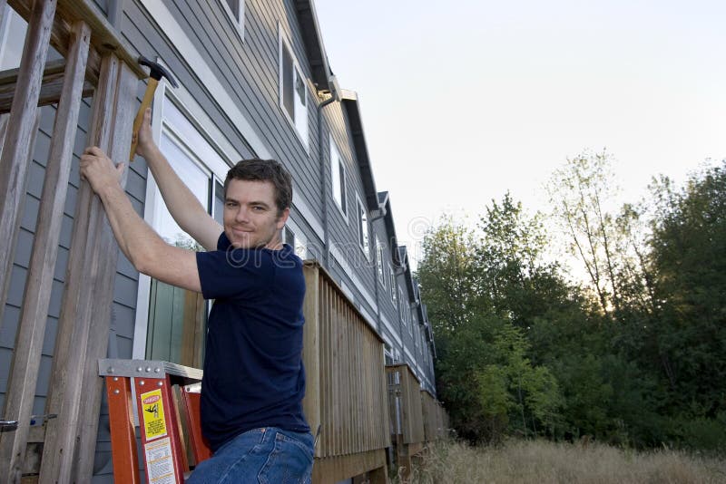 Man Fixing House - Horizontal