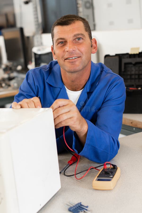 Man fixing microwave oven stock photo. Image of electricity 286471890