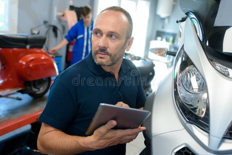 Man Fixing Motorcycle Frame in Stock Photo Image of fixing