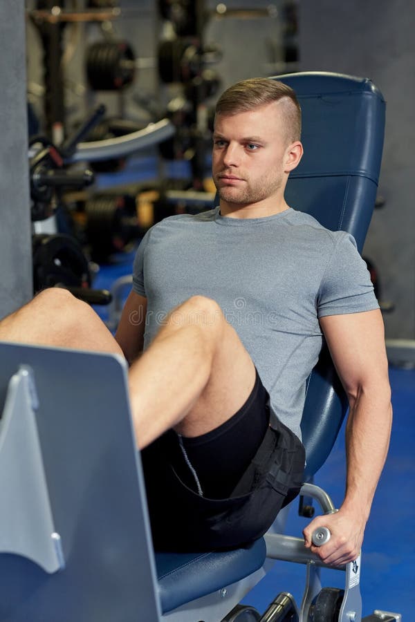 Man Flexing Leg Muscles on Gym Machine Stock Photo - Image of male ...