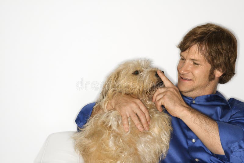 Male Caucasian young adult with fluffy brown dog. Male Caucasian young adult with fluffy brown dog.