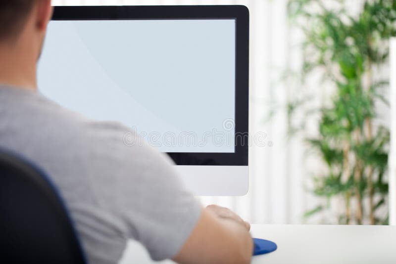 Man in front of computer, back view stock photo