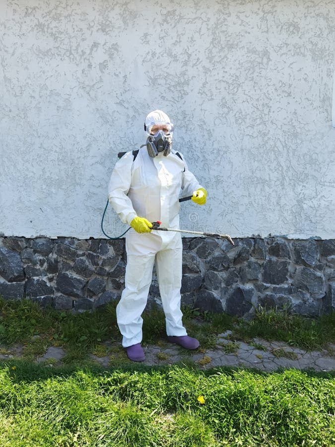 Man in Full Protective Clothing Using Pressure Washer. Stock Image