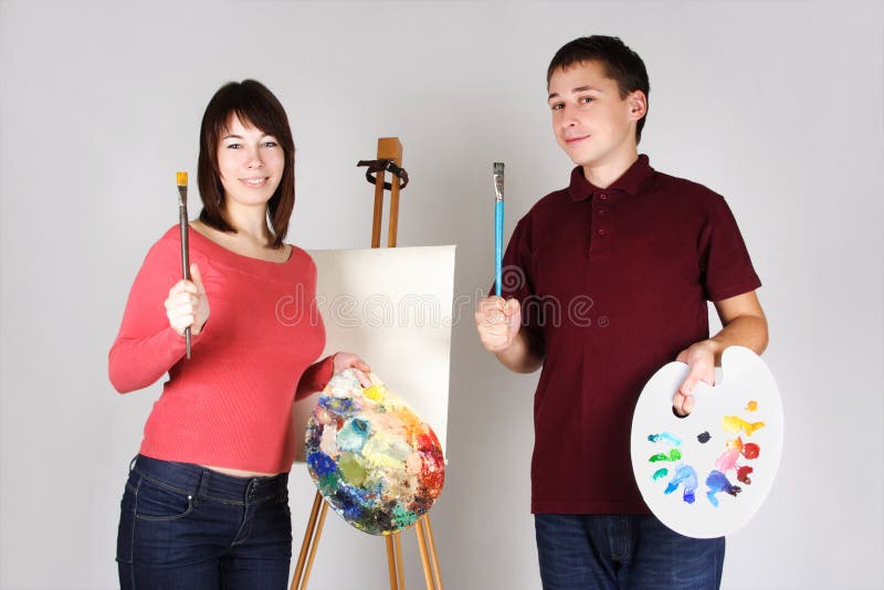 Man and girl artists standing near easel