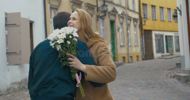 Man Giving Bunch of Flowers to Woman