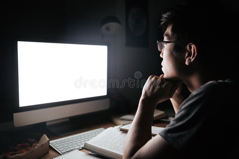Man in glasses studying using blank screen computer.