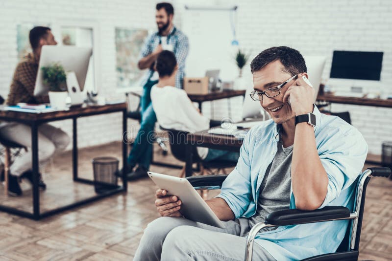 Man in Glasses on Wheelchair with Tablet in Office stock images Man in Glasses on Wheelchair with Tablet in Office stock images