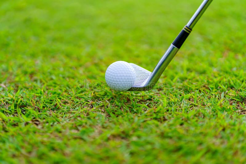 Man Golfer Hitting Ball with Club on Beatuiful Golf Course Stock Photo