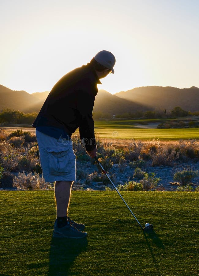 Man golfing as twilight approaches