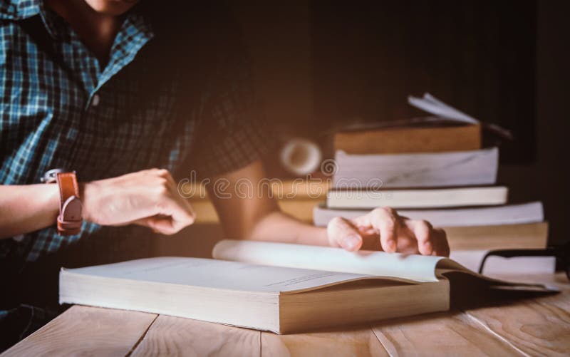 Man in green plaid shirt. Watch time,Sitting on wood chair, reading book on table. stock photos
