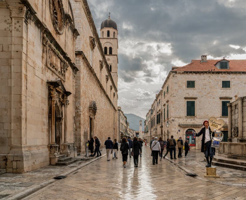 A man greets tourists at the opening gate on the streets of Old Town, the famous landmark in Dubrovnik, Croatia.