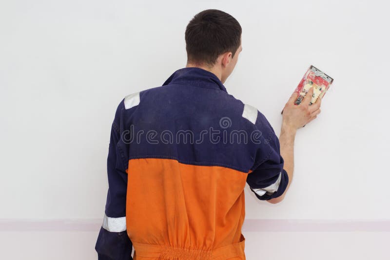 Man Grinding White Wall with Sandpaper Stock Photo Image of