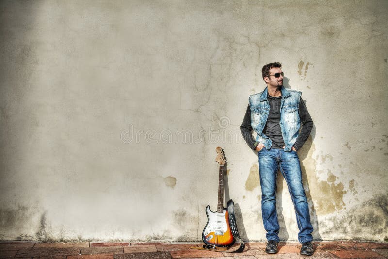 Man and guitar leaning on the wall