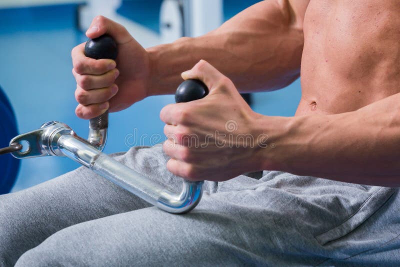 Man in the gym. Working out with weights.Man makes exercises. Sport, power, dumbbells, tension, exercise - the concept of a healthy lifestyle. Article about fitness and sports.