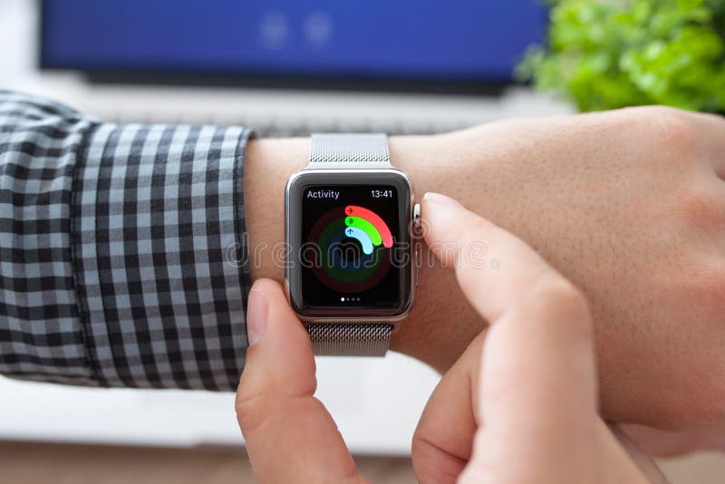 Man hand in Apple Watch with Activity and Macbook stock photography